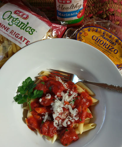 Bowl of Pasta with a Package of Aurelia's Chorizo, Penne Pasta and Jar of Marinara.