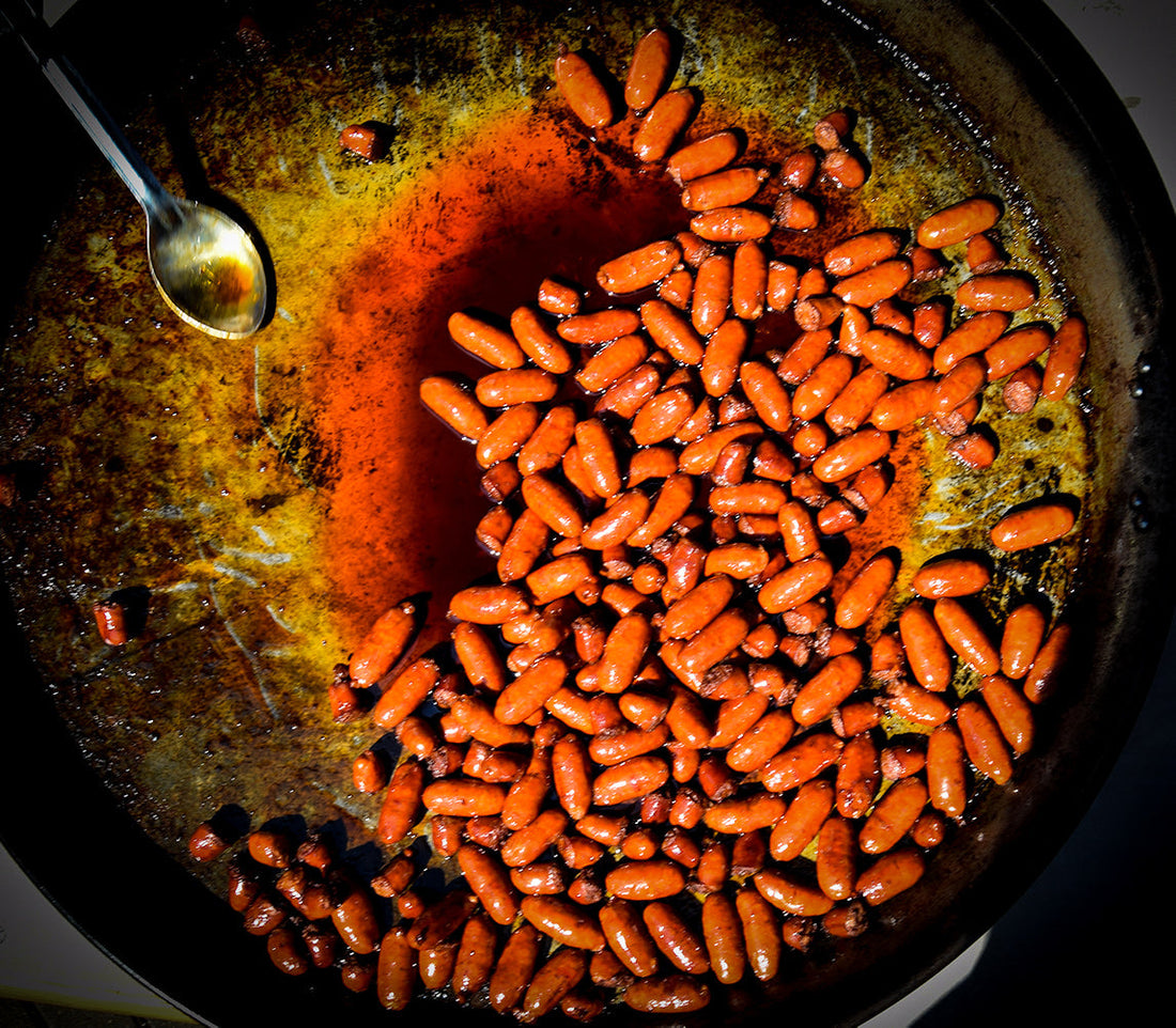 A large paella pan with sizzling, caramelized Besitos.